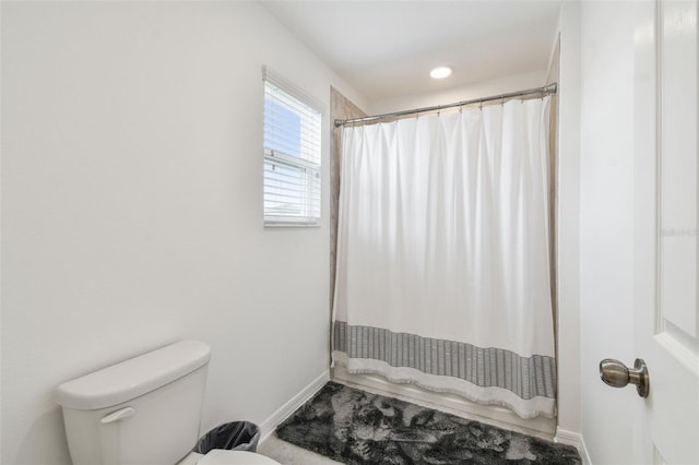 full bathroom with baseboards, toilet, and a shower with shower curtain