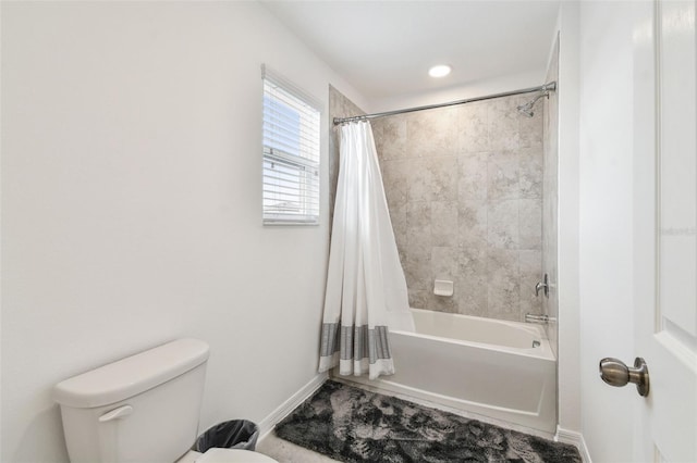 full bathroom with baseboards, shower / tub combo with curtain, and toilet