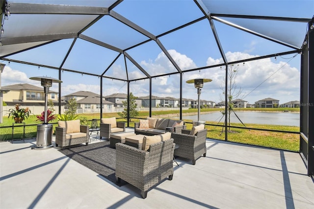 view of patio / terrace featuring outdoor lounge area, a residential view, a water view, and glass enclosure