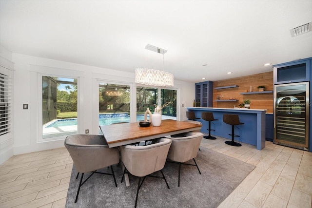 dining area featuring beverage cooler, recessed lighting, light wood-style floors, and visible vents