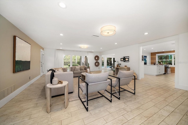 living area with recessed lighting, light wood-style flooring, and visible vents