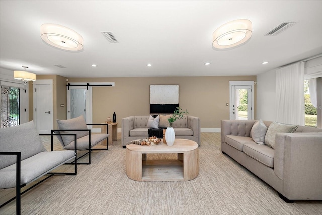 living room with visible vents, a barn door, baseboards, and recessed lighting