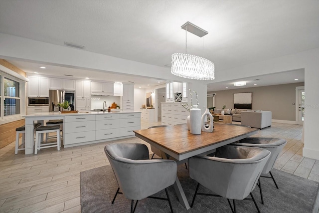 dining area with visible vents, an inviting chandelier, baseboards, light wood-type flooring, and recessed lighting