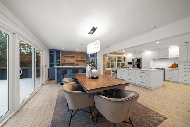 dining room with recessed lighting, a chandelier, and light wood-type flooring