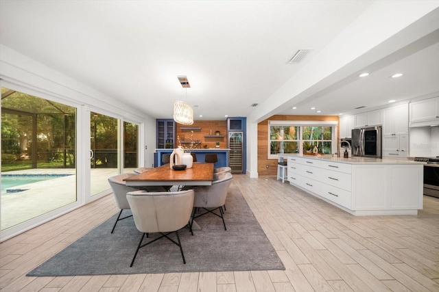 dining room with plenty of natural light, light wood finished floors, recessed lighting, and visible vents