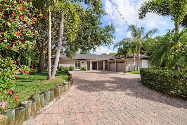 single story home featuring a garage and decorative driveway