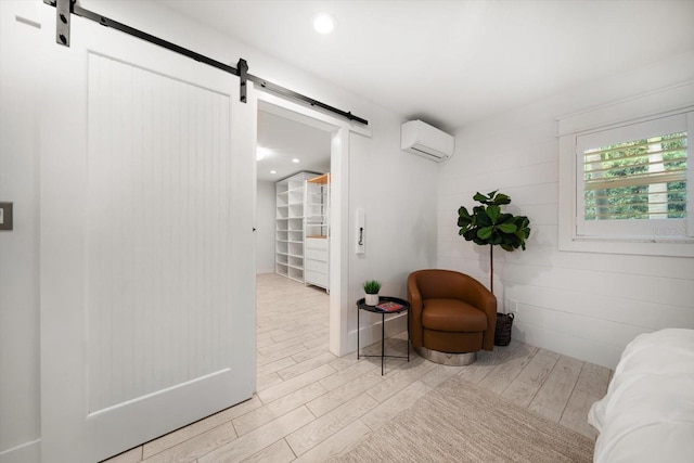 living area featuring recessed lighting, a wall mounted air conditioner, light wood finished floors, and a barn door