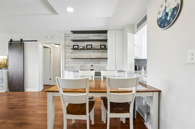 dining area with a barn door, recessed lighting, baseboards, wood finished floors, and visible vents