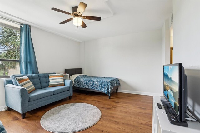 bedroom featuring baseboards, ceiling fan, visible vents, and wood finished floors