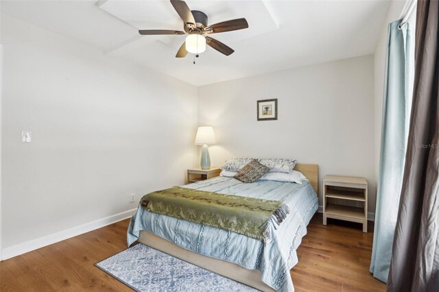 bedroom featuring a ceiling fan, baseboards, and wood finished floors