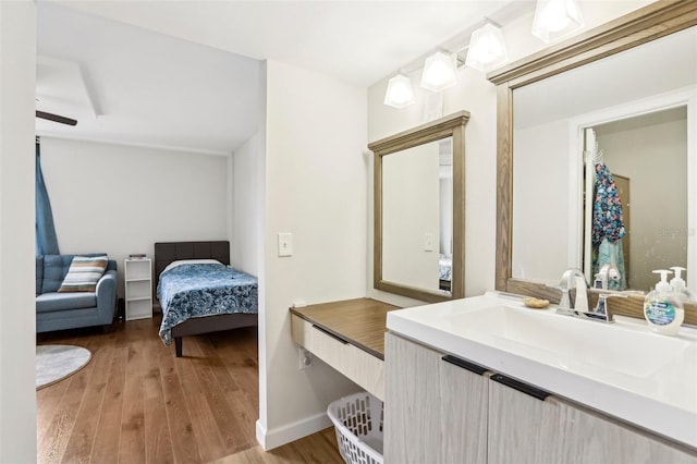 bathroom with ensuite bathroom, baseboards, wood finished floors, and vanity