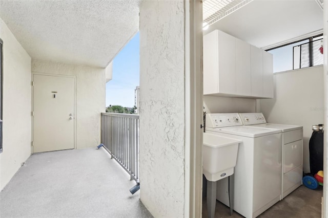 laundry area with independent washer and dryer, a textured ceiling, a textured wall, and plenty of natural light