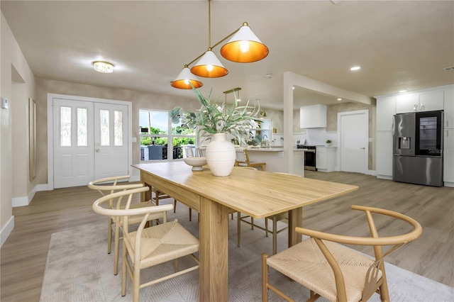 dining space with light wood-style flooring and baseboards