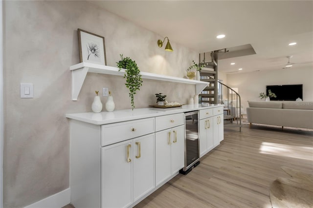 kitchen featuring open shelves, beverage cooler, light wood-style floors, white cabinets, and light countertops