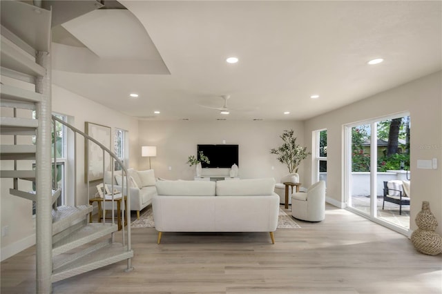 living room with stairs, recessed lighting, light wood-style flooring, a ceiling fan, and baseboards