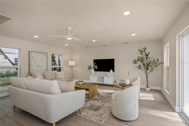 living area featuring plenty of natural light, recessed lighting, light wood-style floors, ceiling fan, and baseboards