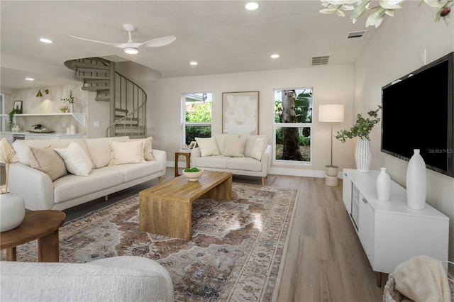 living area with wood finished floors, stairway, recessed lighting, ceiling fan, and baseboards