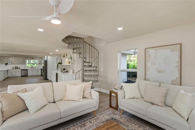 living room with healthy amount of natural light, stairs, light wood-type flooring, recessed lighting, and ceiling fan