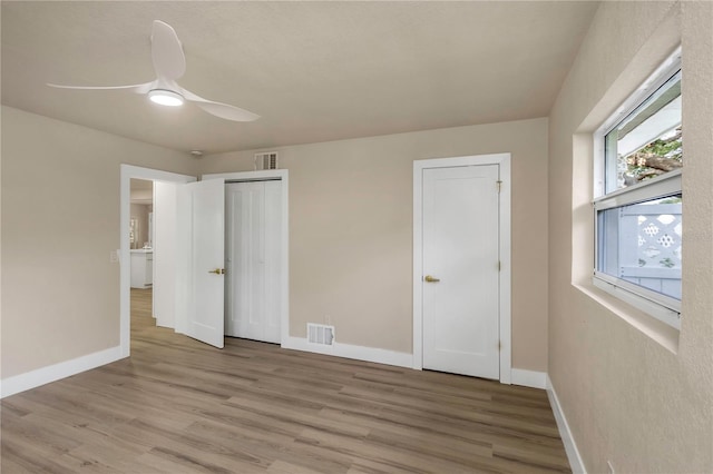 unfurnished bedroom with wood finished floors, baseboards, and ceiling fan