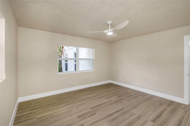 unfurnished room featuring baseboards, a ceiling fan, and light wood finished floors