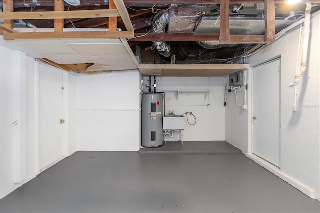basement with electric water heater and a sink