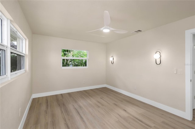 spare room featuring light wood-style flooring, baseboards, and ceiling fan