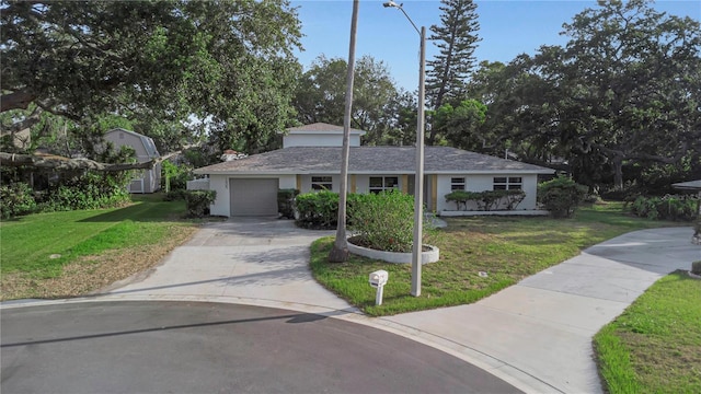 view of front of house featuring a garage, a front lawn, and driveway