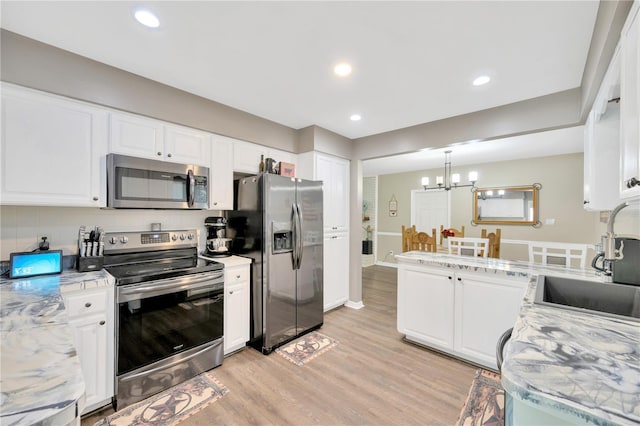 607 Carolyn Dr, Brandon, FL 33510 - kitchen with light countertops, white cabinetry, appliances with stainless steel finishes, and light wood finished floors