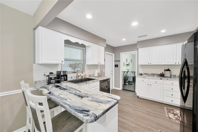 607 Carolyn Dr, Brandon, FL 33510 - kitchen with visible vents, tasteful backsplash, a sink, black appliances, and white cabinetry