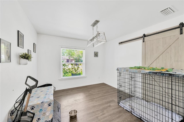 607 Carolyn Dr, Brandon, FL 33510 - miscellaneous room featuring baseboards, visible vents, a barn door, and wood finished floors
