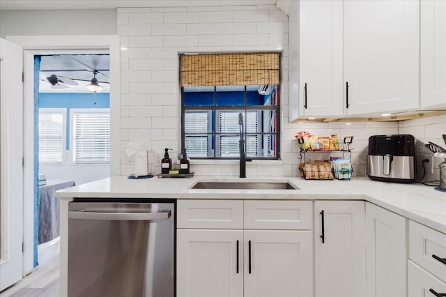 bar with light wood-type flooring, tasteful backsplash, a sink, and dishwasher