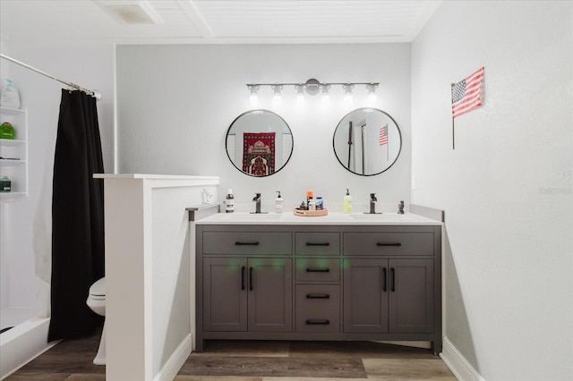 full bathroom featuring double vanity, a sink, wood finished floors, and a shower with curtain