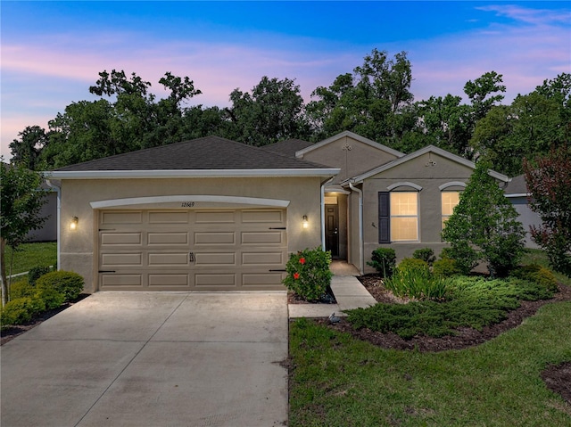 single story home with stucco siding, driveway, and a garage