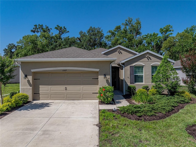ranch-style home with stucco siding, driveway, and a garage
