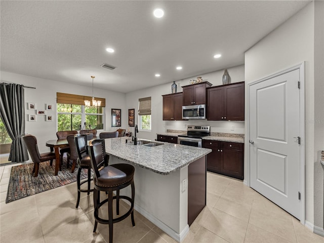 kitchen featuring an inviting chandelier, visible vents, a sink, dark brown cabinetry, and stainless steel appliances