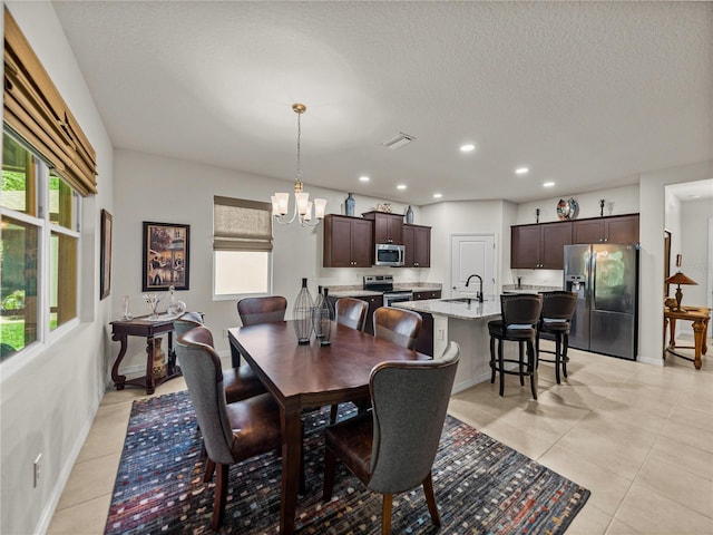 dining room with a chandelier, baseboards, light tile patterned floors, and recessed lighting