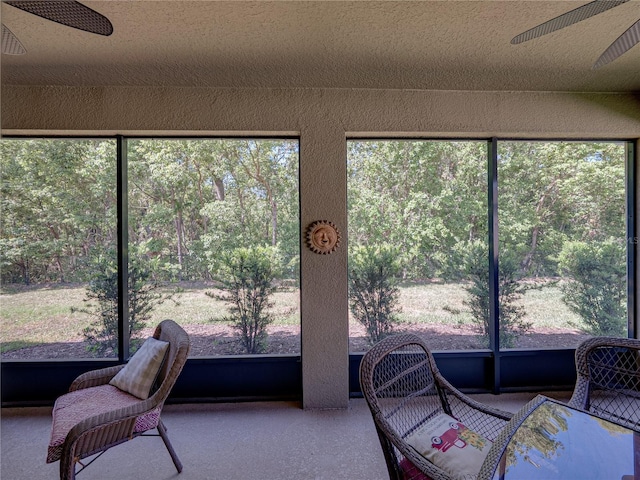 sunroom / solarium featuring a ceiling fan and outdoor dining area