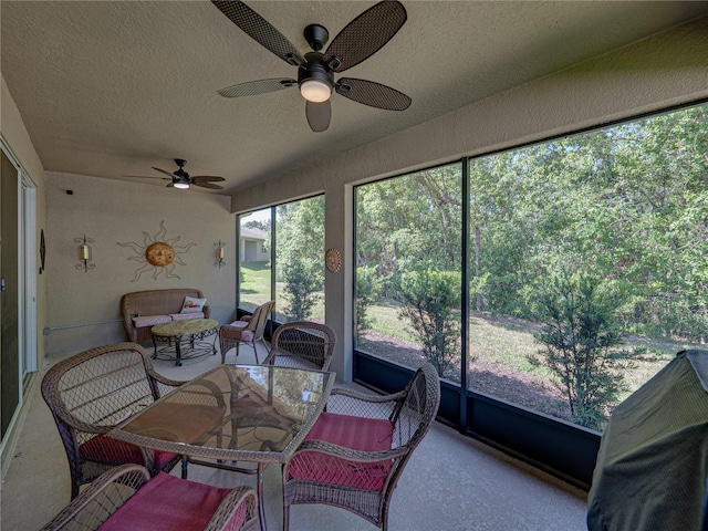 sunroom with ceiling fan and an outdoor living space