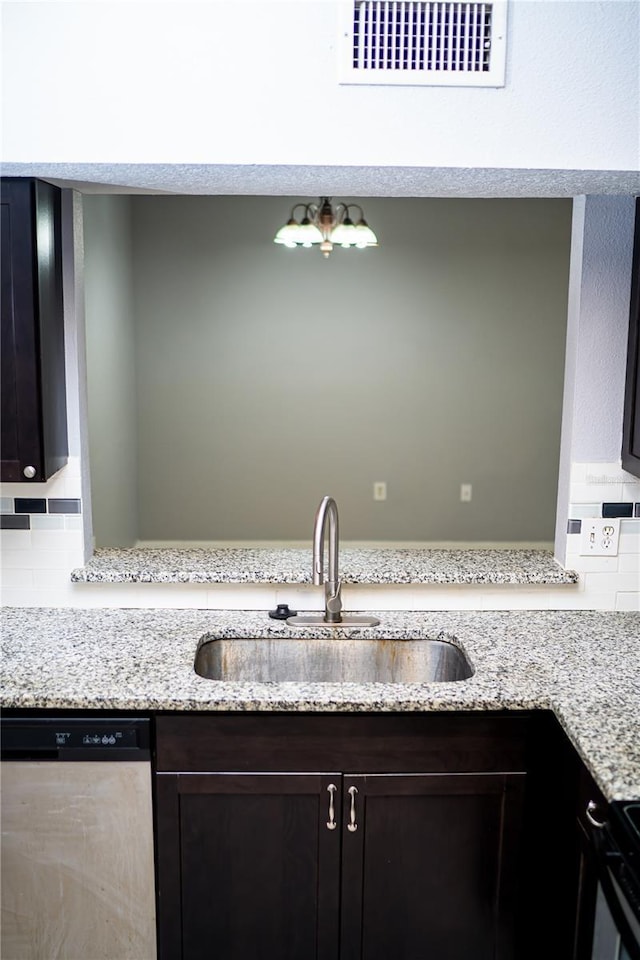 kitchen featuring stainless steel dishwasher, decorative backsplash, visible vents, light stone countertops, and a sink
