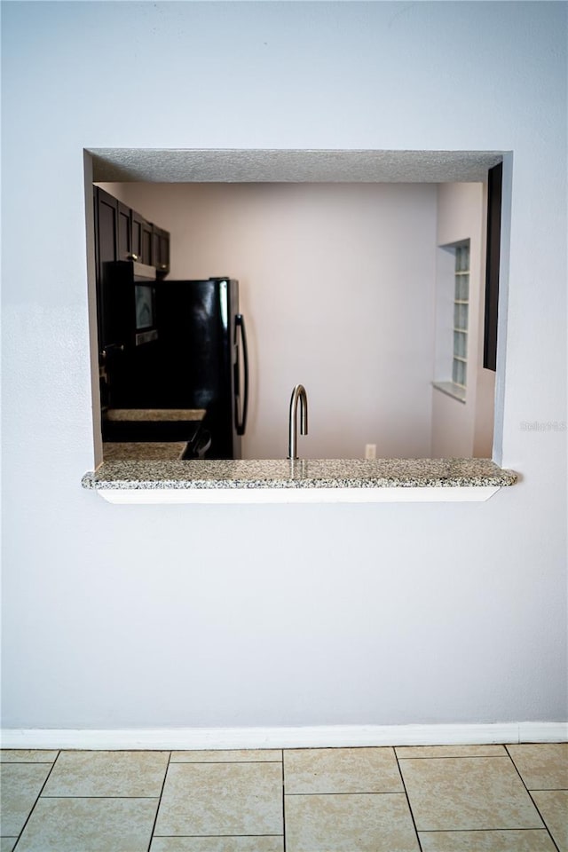 interior details featuring freestanding refrigerator and baseboards