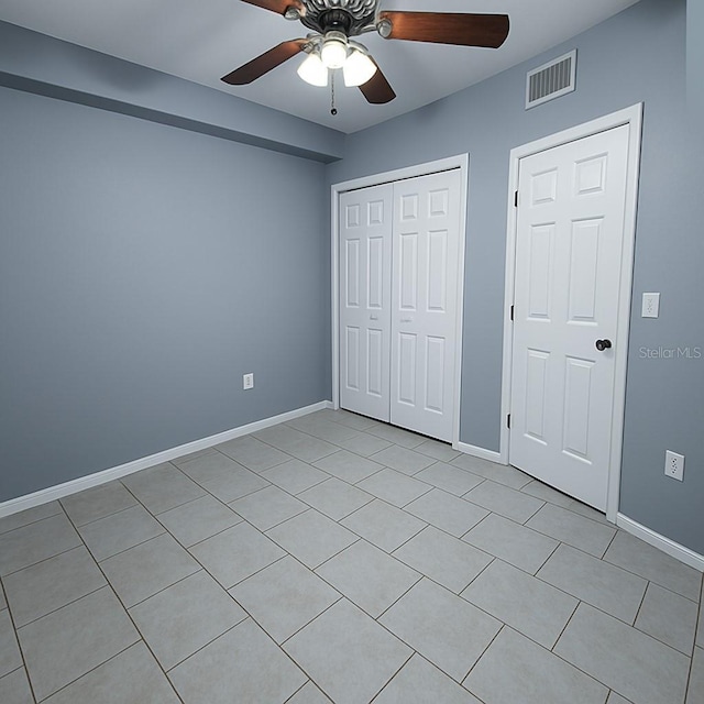 unfurnished bedroom featuring visible vents, baseboards, light tile patterned floors, and a closet