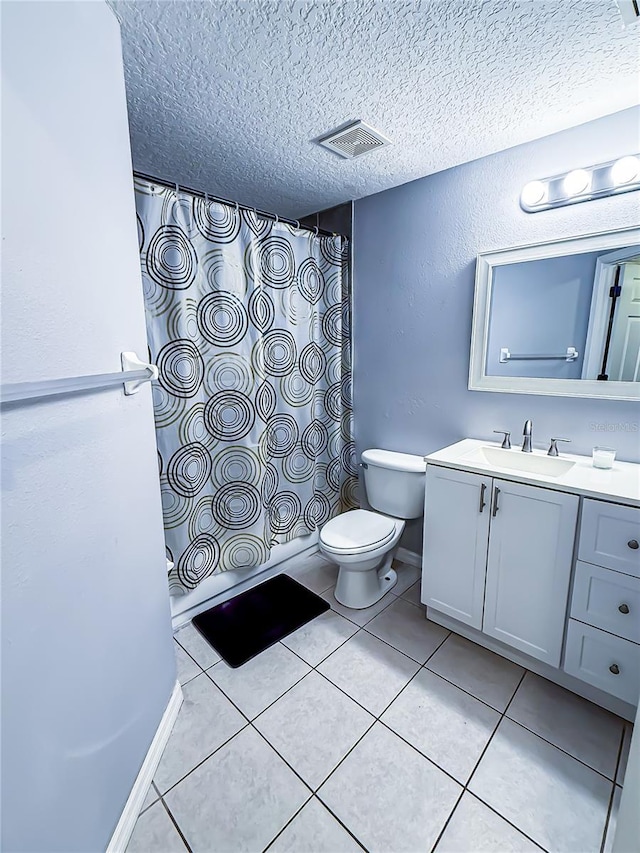 bathroom with tile patterned flooring, vanity, toilet, a textured ceiling, and visible vents