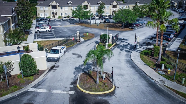 view of road with a residential view, sidewalks, curbs, traffic signs, and street lights