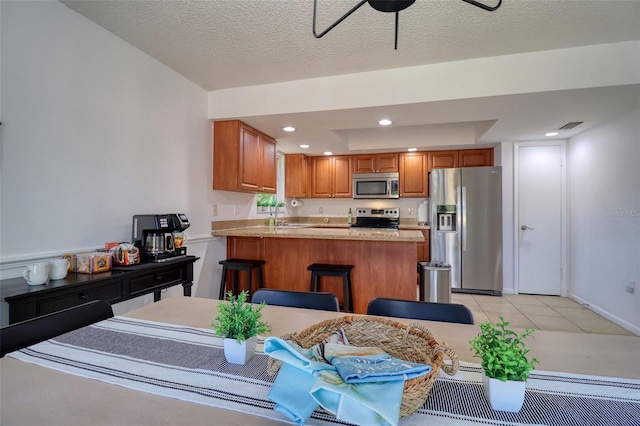 506 Summerwood Ct, Tarpon Springs, FL 34689 - kitchen featuring stainless steel appliances, a peninsula, brown cabinets, light countertops, and a ceiling fan
