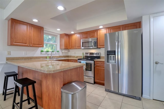 506 Summerwood Ct, Tarpon Springs, FL 34689 - kitchen featuring stainless steel appliances, a sink, a peninsula, a breakfast bar area, and light tile patterned floors