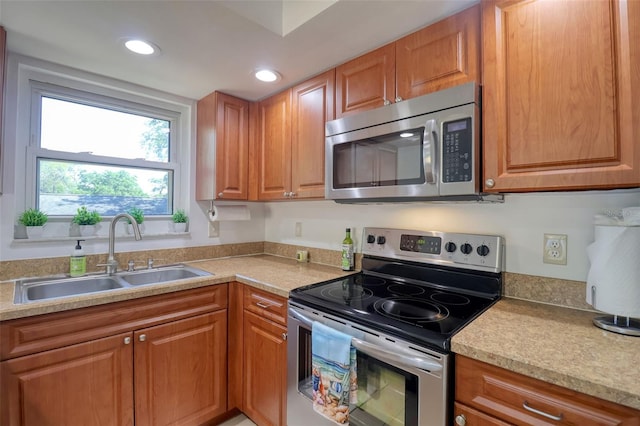 506 Summerwood Ct, Tarpon Springs, FL 34689 - kitchen with stainless steel appliances, a sink, light countertops, brown cabinetry, and recessed lighting