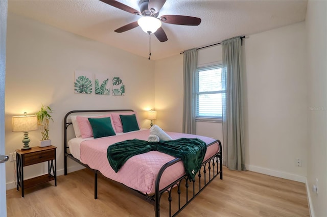 506 Summerwood Ct, Tarpon Springs, FL 34689 - bedroom with light wood-style flooring, baseboards, a ceiling fan, and a textured ceiling