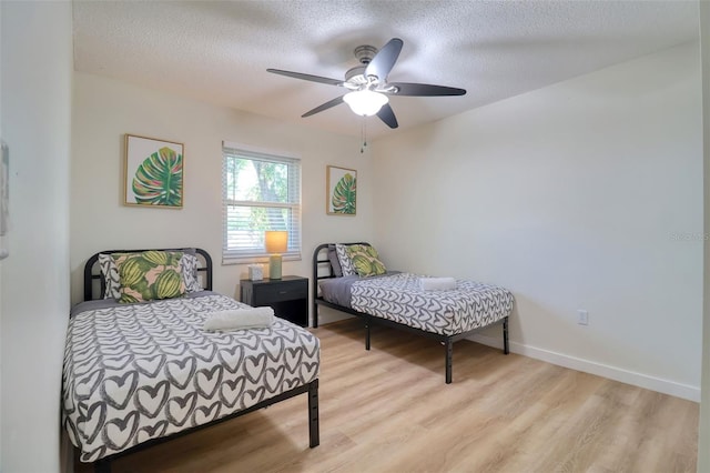 506 Summerwood Ct, Tarpon Springs, FL 34689 - bedroom with light wood-type flooring, a textured ceiling, baseboards, and ceiling fan