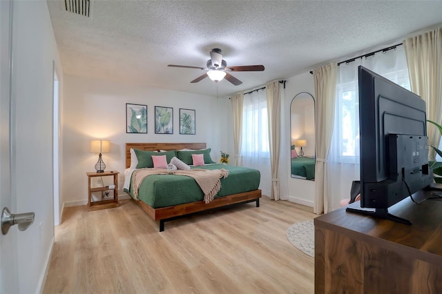 506 Summerwood Ct, Tarpon Springs, FL 34689 - bedroom with a textured ceiling, baseboards, light wood-style floors, and a ceiling fan