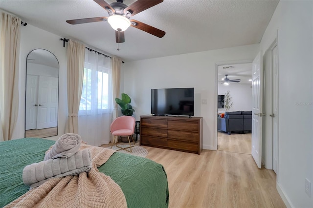 506 Summerwood Ct, Tarpon Springs, FL 34689 - bedroom featuring light wood-style floors, a ceiling fan, a textured ceiling, and baseboards